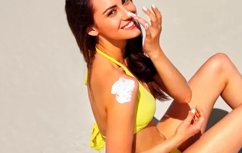 Mujer echándose crema para protegerse del sol