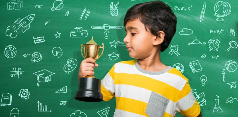 Niño mostrando un trofeo conseguido en la escuela