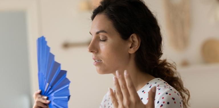 Una mujer sufiendo sofocos premenopáusicos