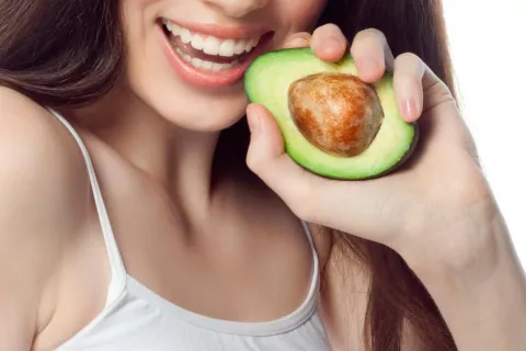 Mujer con un aguacate en la mano