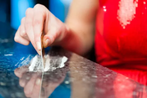 Mujer preparando unas 'rayas' de cocaina