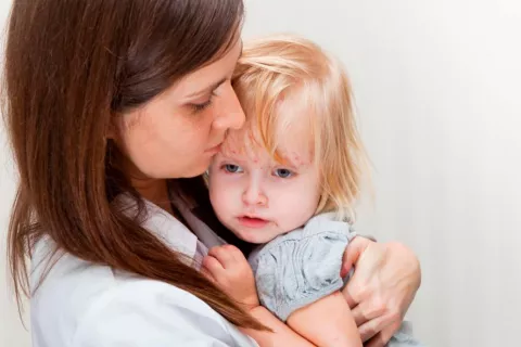 Una madre con a su hija pequeña en brazos