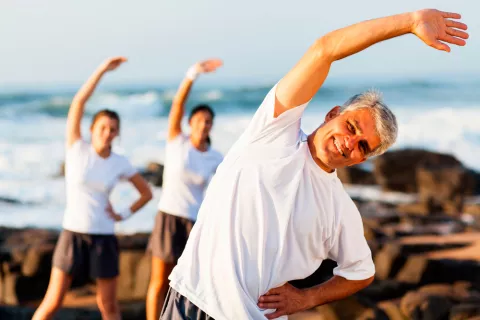 Varias personas hacen ejercicio junto al mar