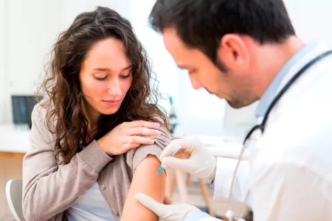 Un sanitario vacuna a una mujer