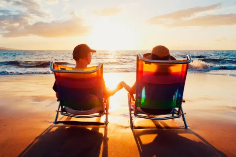 Una pareja contempla la puesta de sol en la playa