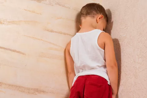 Niño castigado de cara a la pared