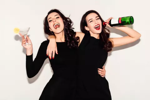 Hermanas adolescentes imitando conducta con el alcohol