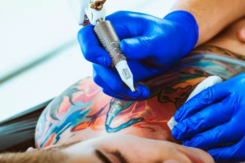 Un profesional realizando un tatuaje de colores