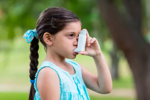 Niña utilizando un inhalador para el asma