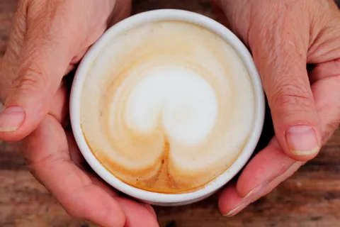 Persona mayor con una taza de café en las manos