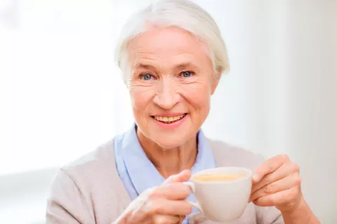 Una mujer ingiere una taza de café caliente