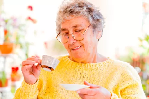 Mujer mayor tomando café