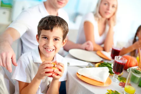 Niño comiendo fruta en familia