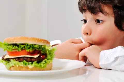 Niño se va a comer una hamburguesa