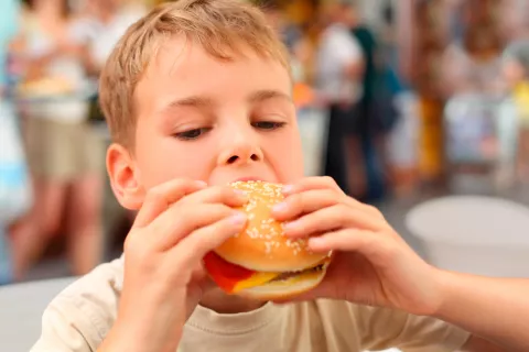 Un niño comiéndose una hamburguesa