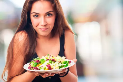 Chica joven con un plato de ensalada