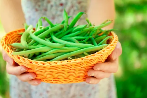 Mujer en la manopausia mostrando su dieta a base de judías verdes