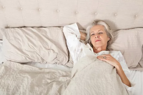 Mujer mayor durmiendo en la cama