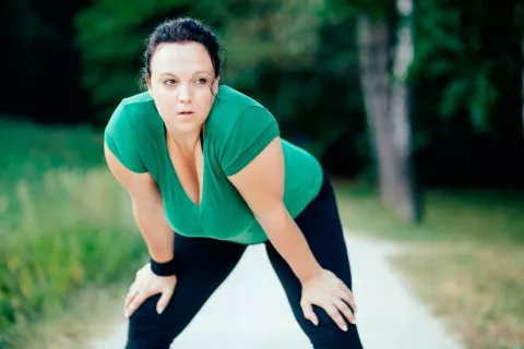 Una mujer con sobrepeso practica ejercicio al aire libre