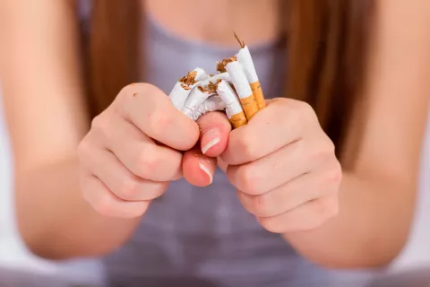 Mujer con EPOC rompiendo cigarrillos