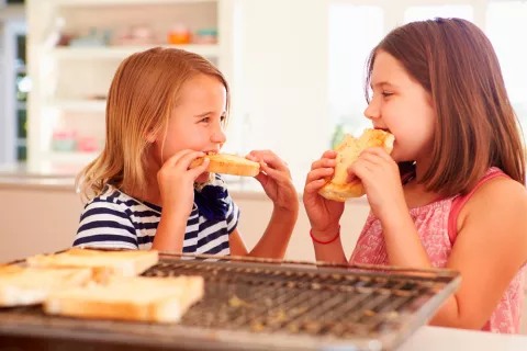 Dos niñas comen pan tostado