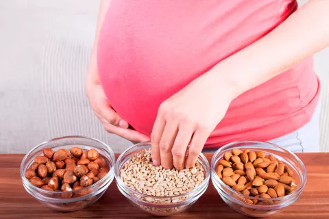 Mujer embarazada comiendo frutos secos