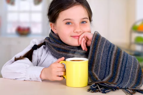 Niña tomando una infusión de jengibre para aliviar la gastroenteritis