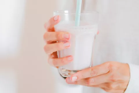 Mujer tomando vaso de leche entera