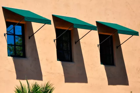 Casa con toldos que dan sombra a las ventanas