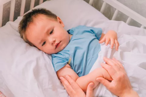 Niño pequeño enfermo en su cuna