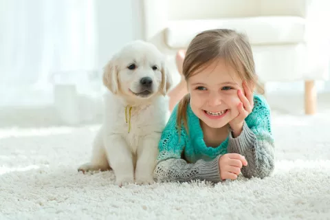 Niña sonríe en compañía de su mascota