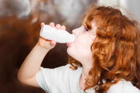 Niña bebiendo yogur probiótico