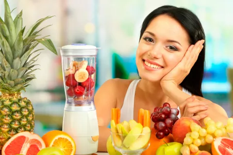 Mujer haciendo zumo de frutas con plátano