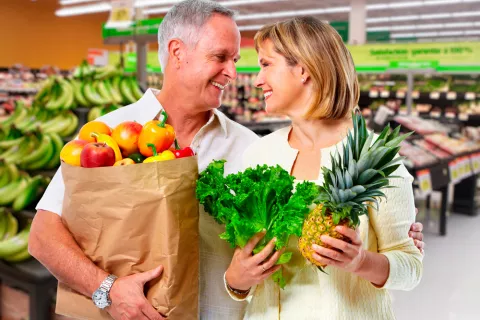 Pareja comprando fruta en abundancia