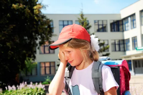 Una niña llora camino del colegio