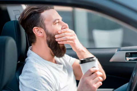 Persona con sueño conduciendo un coche