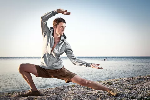 Hombre practicando taichí en la playa