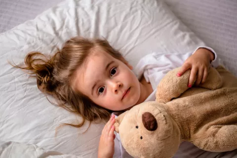 Niña pequeña abraza a su osito antes de dormir