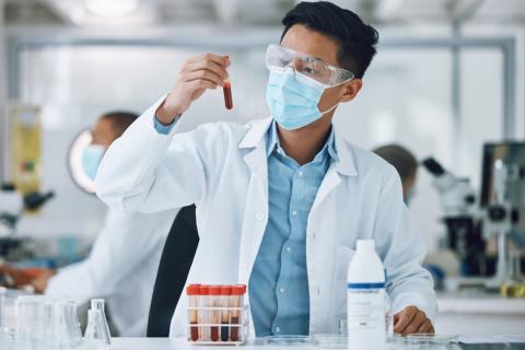 Investigador sostiene un tubo con sangre en un laboratorio