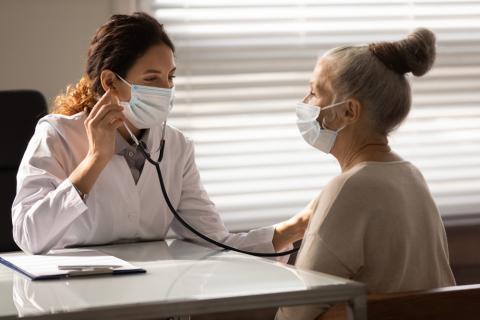 Doctora ausculta a una mujer con COVID persistente