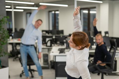 Grupo de trabajadores haciendo ejercicio en la oficina