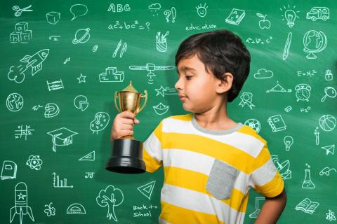 Niño mostrando un trofeo conseguido en la escuela