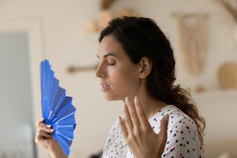 Una mujer sufiendo sofocos premenopáusicos