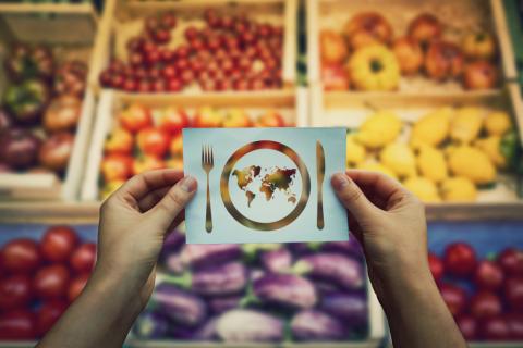 Imagen del planeta sobrepuesta sobre un puesto de frutas y verduras