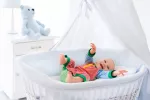 Bebé risueño moviéndose en su cuna Movimientos espontáneos del bebé: descubre cuál es su propósito