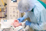 La detección precoz de AME en recién nacidos revoluciona su pronóstico Doctor examinando a un recién nacido