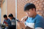Adolescente fumando mientras mira su teléfono móvil