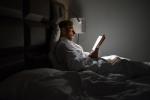 Persona joven leyendo por la noche en la cama