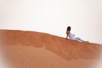 Mujer embarazada tumbada en una duna del desierto