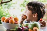 Niño comiendo fruta al aire libre